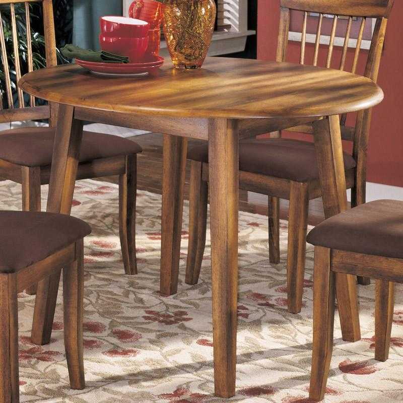 Ashley 2-4 person round kitchen table in warm wood finish with matching chairs on floral rug