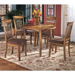 Ashley 2-4 person round kitchen table with wooden finish and matching chairs in dining room